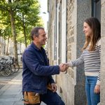 artisan rennais souriant devant une maison rénovée