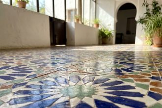 Carrelage zellige marocain traditionnel aux motifs géométriques étoilés en bleu cobalt et terracotta dans un salon méditerranéen