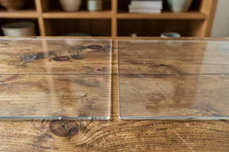 Comparaison de deux épaisseurs de nappe cristal sur une table en chêne, montrant la protection du bois