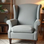 Housse extensible unie gris tourterelle sur fauteuil à oreilles dans un salon cosy