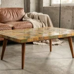 Table basse style Roger Capron avec plateau en céramique mosaïque, posée dans un salon minimaliste parisien aux murs en béton brut